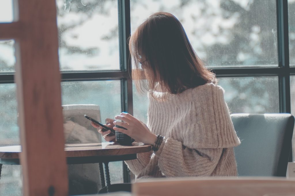 manhadedomingo garota em um café com o celular