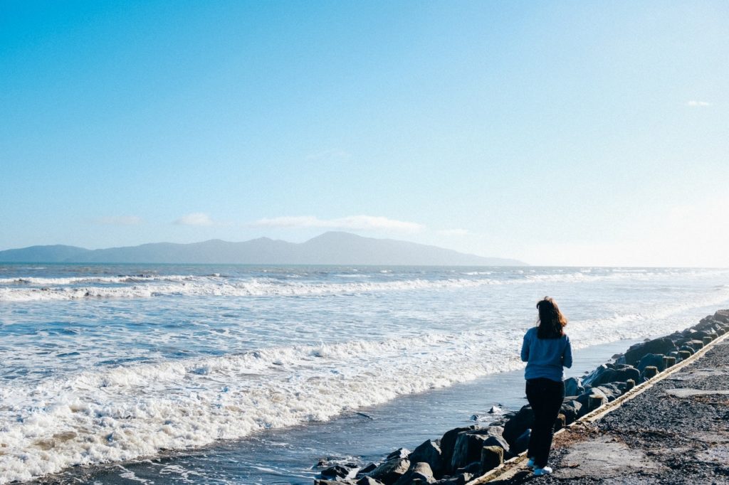 manhã de domingo mulher andando na praia epifanias de mochilão