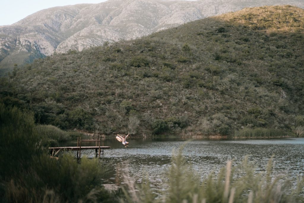 manhã de domingo pessoa pulando no lago epifanias de mochilão